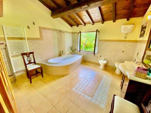 uma grande casa de banho com banheira e lavatório em VILLA NOCRI - Piscina & Sauna esclusiva em Montefranco