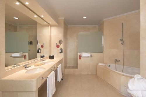 La salle de bains est pourvue de 2 lavabos, d'une baignoire et d'une douche. dans l'établissement Exe Oviedo Centro, à Oviedo