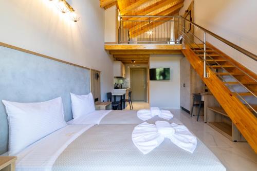 a bedroom with a large white bed with a staircase at Sky View Suites Kefalonia in Vóvikes