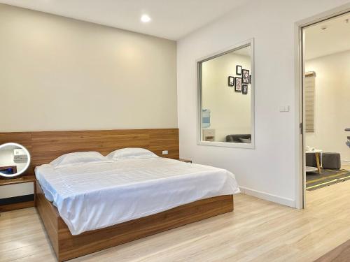 - une chambre avec un grand lit et un miroir dans l'établissement Pan House, à Hanoï