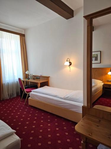 a hotel room with a bed and a desk at Gasthof Klement in Isen