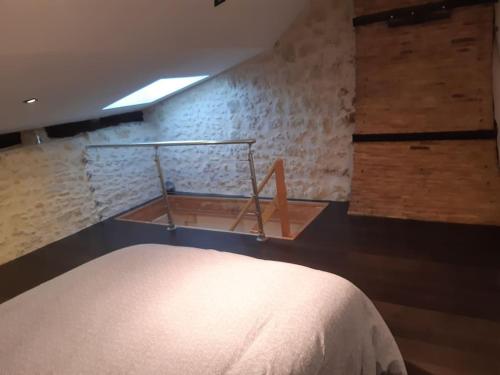 une chambre avec un lit et un mur dans l'établissement Le Petit Nid, à Saint-Loubès