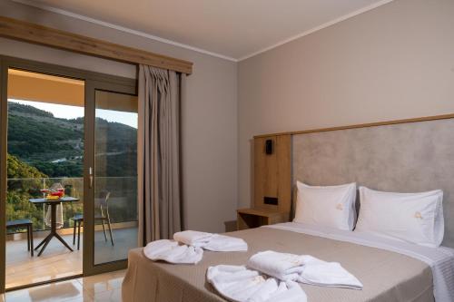 a bedroom with a bed with towels on it at Sky View Suites Kefalonia in Vovikes