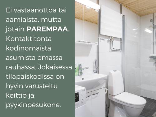 a bathroom with a white toilet and a sink at Hiisi Homes Vantaa Keimolanmäki in Vantaa
