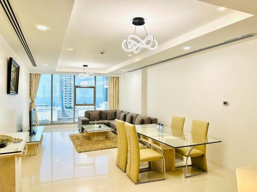 uma sala de estar com uma mesa de jantar e um sofá em Kiev Tower Hotel Apartments em Manama