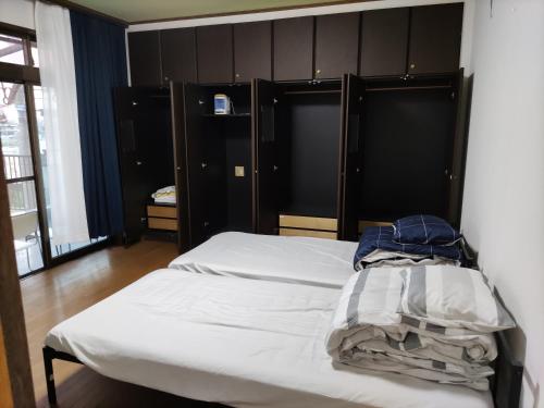 a bedroom with two beds with black headboards at 和室+洋室+日本酒飲放題/Premier Guest House 