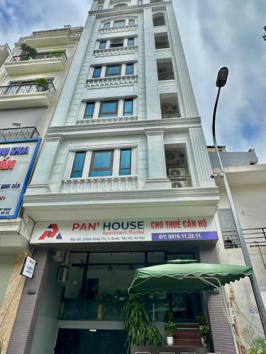 a large white building with a sign in front of it at Pan House in Hanoi