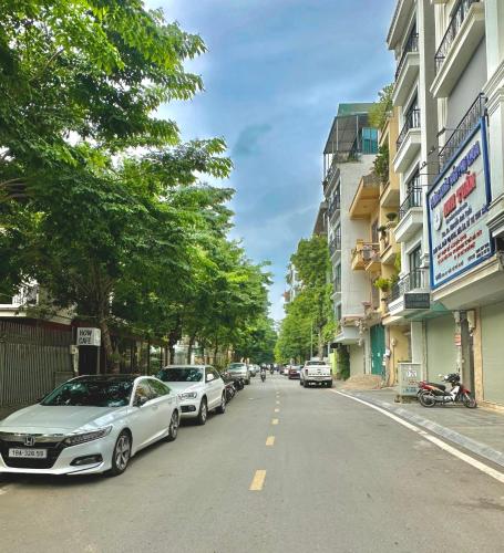 a street with cars parked on the side of the road at Pan House in Hanoi