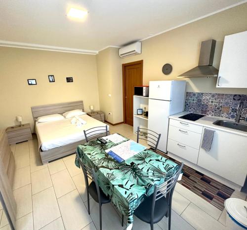 eine Küche mit einem Tisch und einem Bett in einem Zimmer in der Unterkunft Grab a Flat in Coroneo in Triest