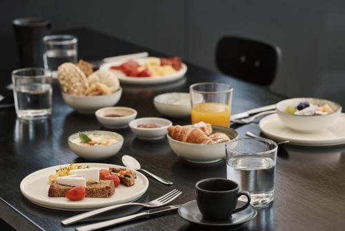 a table with plates of breakfast foods and glasses of orange juice at The Newel Psychiko in Athens