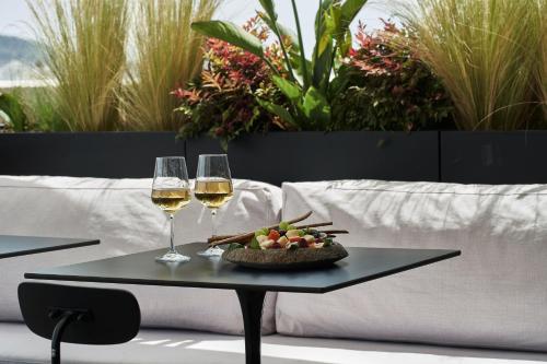 a table with two glasses of wine and a bowl of fruit at The Newel Psychiko in Athens