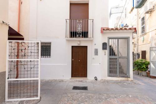 a white building with a wooden door on a street at I Catui dei Marinai in Diamante