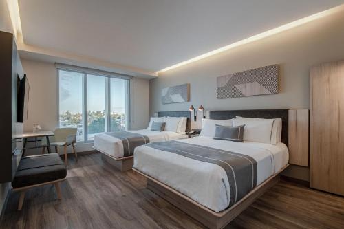 墨西卡利的住宿－City Express Plus by Marriott Mexicali，酒店客房配有两张床和一张书桌