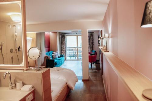ein Hotelzimmer mit einem Bett und einem Spiegel in der Unterkunft Hotel Goldener Berg in Lech am Arlberg