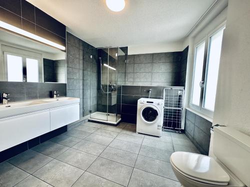 a bathroom with a washer and dryer in it at Monteurzimmer ZIMMERzuVERMIETEN in Lengnau BE in Lengnau