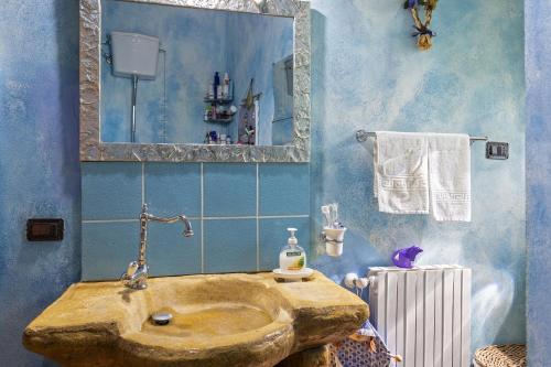 a bathroom with a stone sink and a mirror at Villino Il Melograno in Menfi