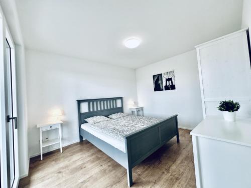 ein Schlafzimmer mit einem Bett in einem weißen Zimmer in der Unterkunft BUSINESS APARTMENT in Deitingen Tiny House ZIMMERzuVERMIETEN in Deitingen