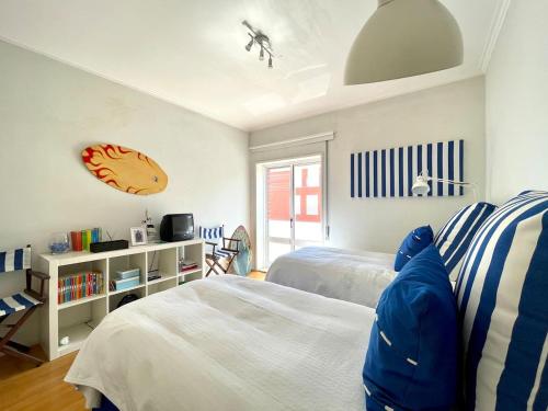 a bedroom with two beds and a clock on the wall at Apartamento Ofir in Fão