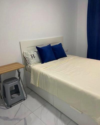 a bedroom with a bed with blue pillows and a table at Your Perfectt place in Valencia