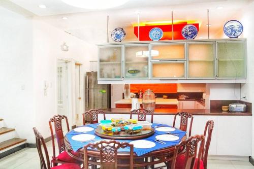 una cocina con una mesa con sillas y platos. en Melia's House Tagaytay - Nature Home for Rent, en Tagaytay