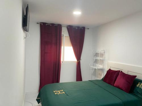 a bedroom with a green bed and a window at Your Perfectt place in Valencia