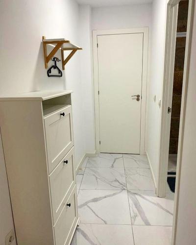 a white kitchen with a counter and a door at Your Perfectt place in Valencia