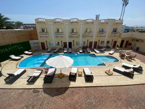 a swimming pool with lounge chairs and an umbrella at Lidia Dahab Hotel and Restaurant in Dahab