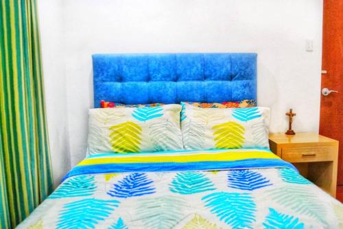 1 cama con cabecero azul y 2 almohadas en Melia's House Tagaytay - Nature Home for Rent, en Tagaytay