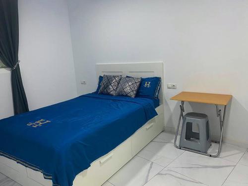 a bedroom with a blue bed and a table at Your Perfectt place in Valencia