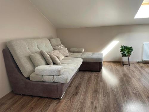 a living room with a large couch in a room at Aerodromas! Kunigiškiai in Palanga