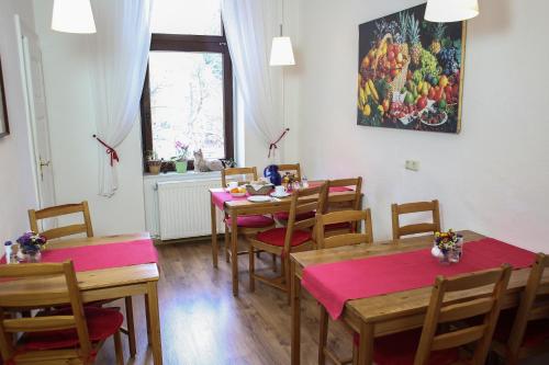 a dining room with tables and chairs and a painting on the wall at Pension Siewert in Dessau