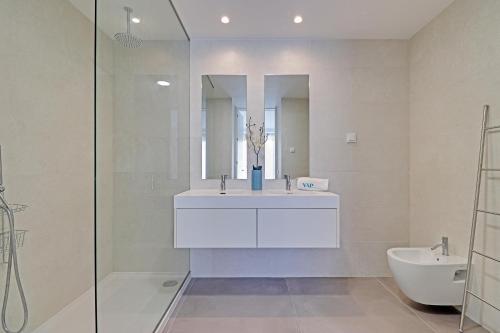 a white bathroom with a sink and a toilet at The Villa in Vilamoura