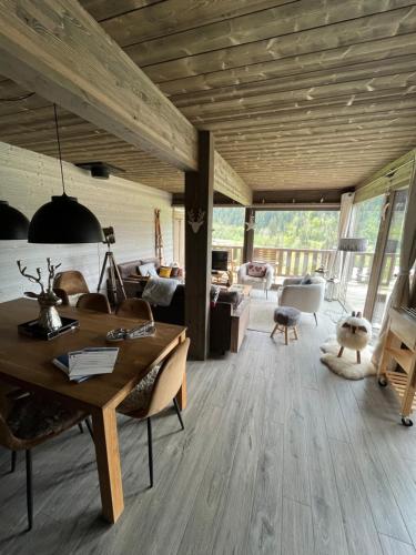 a living room with a wooden ceiling and a table at Chalet Alpaga 3 classé 4 étoiles in Châtel