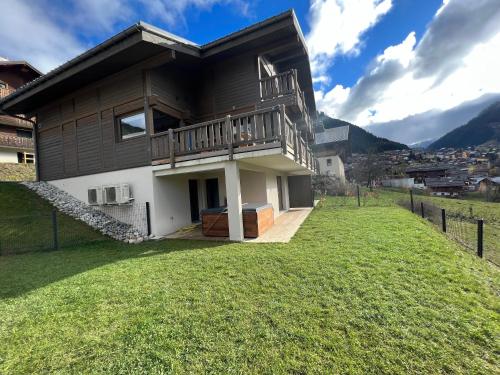 a house on a hill with a yard at Chalet Alpaga 3 classé 4 étoiles in Châtel