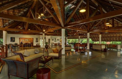 a living room with couches and tables in a building at Rhythm Kumarakom in Kumarakom