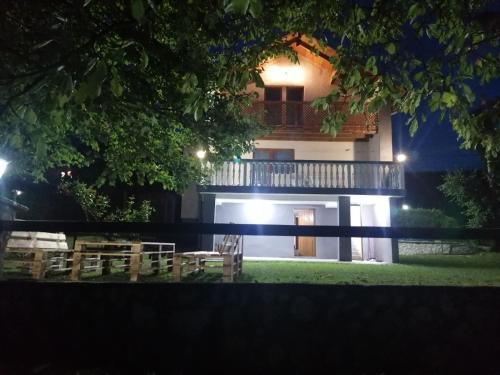 a building with a balcony with tables and chairs at night at Tranquil Retreat - "Villa Green Oasis" in Sarajevo