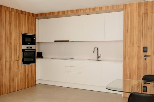 a kitchen with white cabinets and a sink at Europa Apartments in Hospitalet de Llobregat