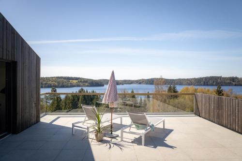eine Terrasse mit 2 Stühlen und einem Sonnenschirm auf dem Balkon in der Unterkunft Villa Sara in Landvetter