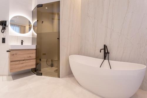 una vasca bianca in bagno con lavandino di Magnificent Renovated 2BD 2BTH Duplex with Backyard - City Centre a Málaga