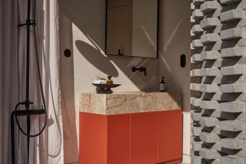 a bathroom with a red counter and a wall at The Newel Psychiko in Athens
