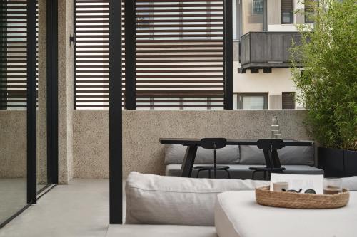 a patio with a table and a couch at The Newel Psychiko in Athens