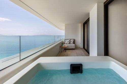 a bath tub with a view of the ocean at Isla Brown Corinthia Resort & Spa, Curio Collection by Hilton in Agioi Theodoroi