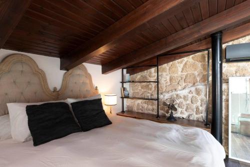 um quarto com uma cama grande e uma parede de pedra em Luxury Villa by the Beach in Neve Tzedek's Heart! em Tel Aviv