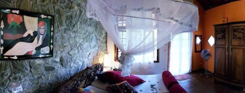 a living room with a couch and a stone wall at Singharaja Garden AGRO ECO Lodge in Pelawatta