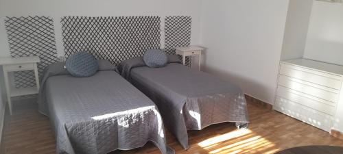 two twin beds in a room with two tables at Sol y Luna "Desayuno Incluido" in Manzaneque
