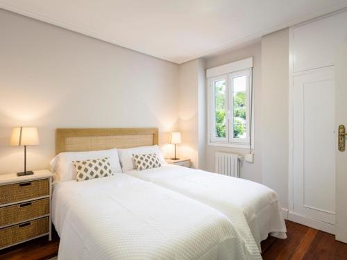 Un dormitorio blanco con una cama grande y una ventana en housingcoruña ZAPATEIRA, en A Coruña