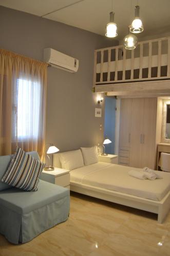 a bedroom with two beds and a couch at Ammos Apartments in Glida