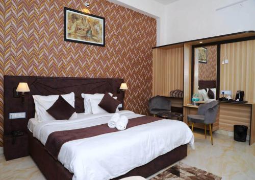 een hotelkamer met een groot bed en een bureau bij HOTEL MAYURA in Ajmer