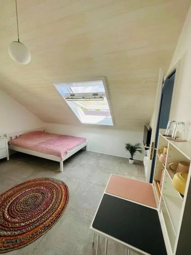 Zimmer im Dachgeschoss mit einem Bett und einem Teppich in der Unterkunft appartme. XS in Bad Herrenalb