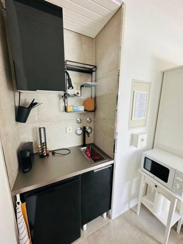 eine kleine Küche mit einer Theke und einer Mikrowelle in der Unterkunft appartme. XS in Bad Herrenalb